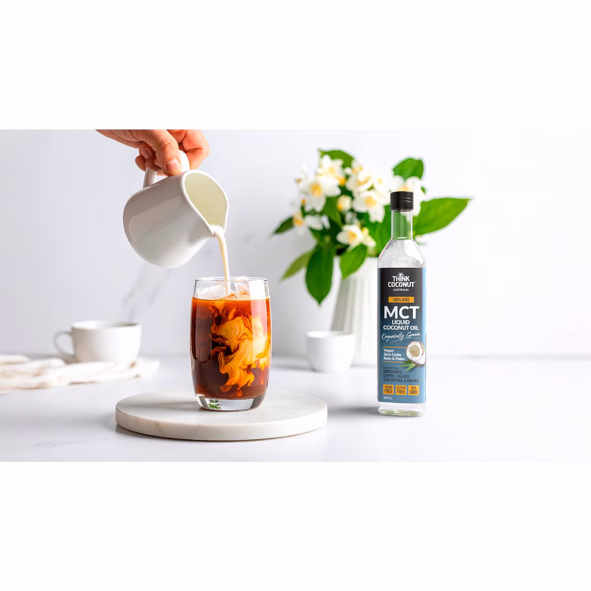 Bullet iced coffee in a tall glass with ice, topped with creamy foam and a straw